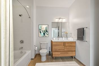 A bathroom with a white tub, toilet, and sink.